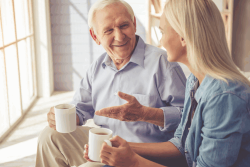 Senior und Frau unterhalten sich und trinken eine Tasse Kaffee